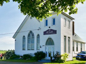 an old country church building with the sign The Table Culinary Studio