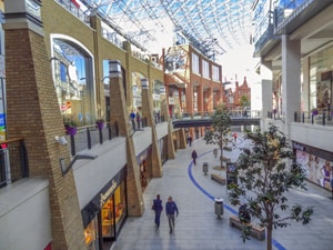 a street with old buildings and a modern mall - seen on a black taxi tour of Belfast