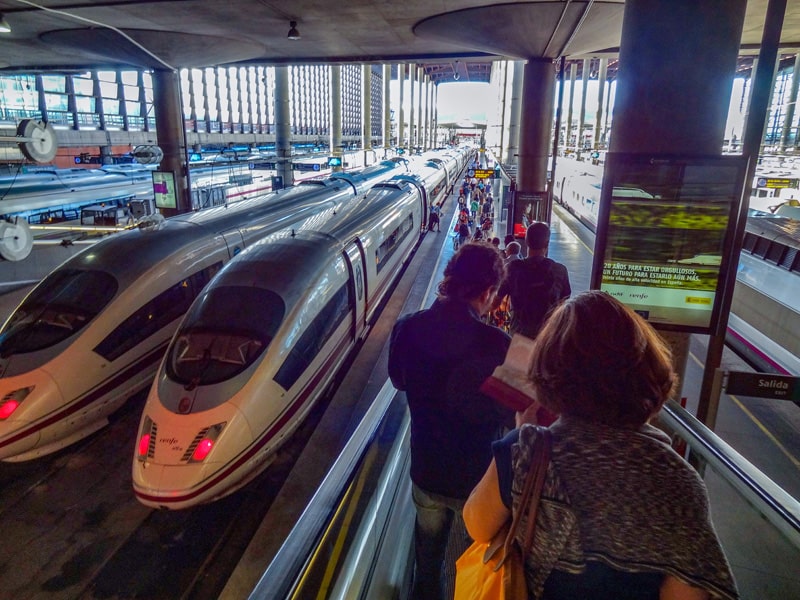 trains in a station with people taking day trips from Madrid