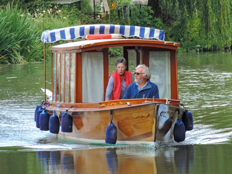 a couple in a canal boat on a river in England