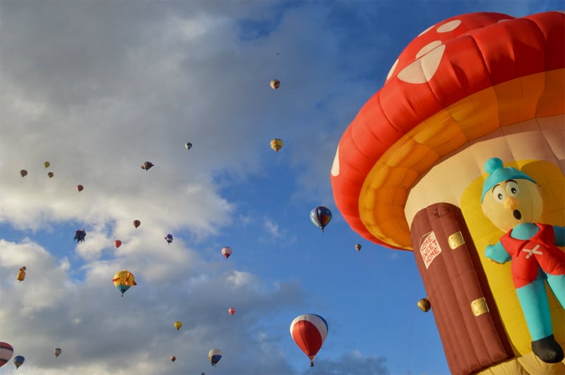 a large number of hot-air balloons drifting skyward