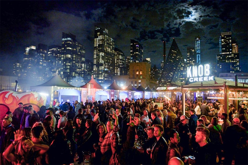 nighttime at a fall festival in front of the NY skyline