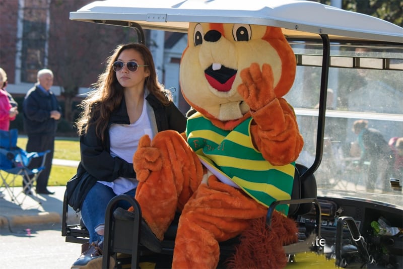 a woman in a parade with person in a chipmunk costume