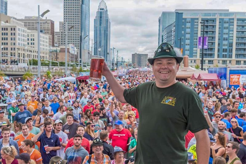 a man in a crowd holding a stein of beer