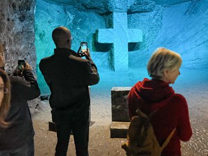 people looking at a cross in a salt mine
