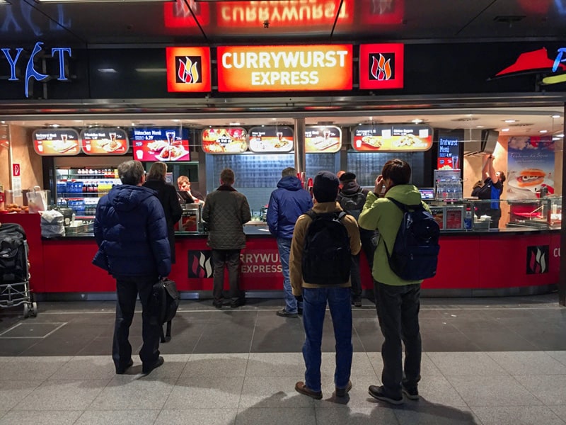 people at a wurst stand buying currywurst