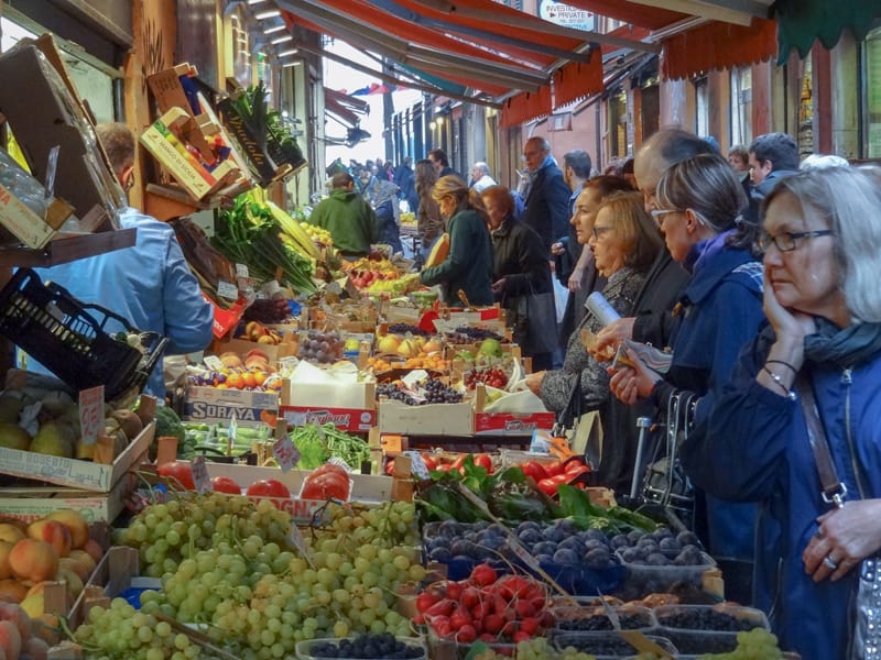 a crowd shopping at a vegetable market