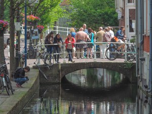people on a bridge on a canal seen  during day trips from Amsterdam