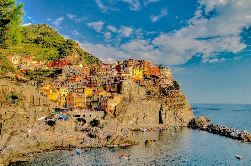 a colorful village on a rocky cliff by the sea