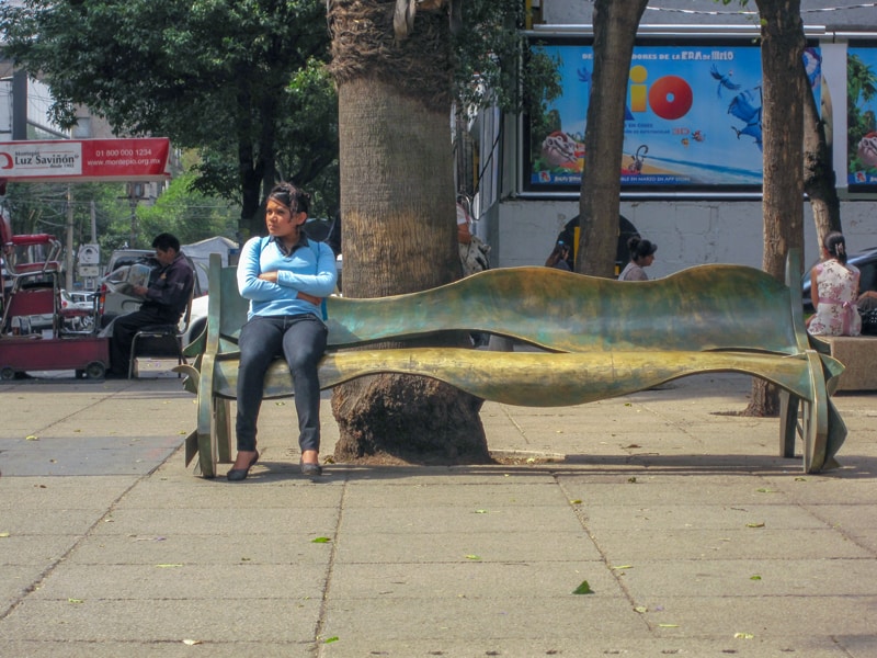 a young woman sitting on a fanciful park bench