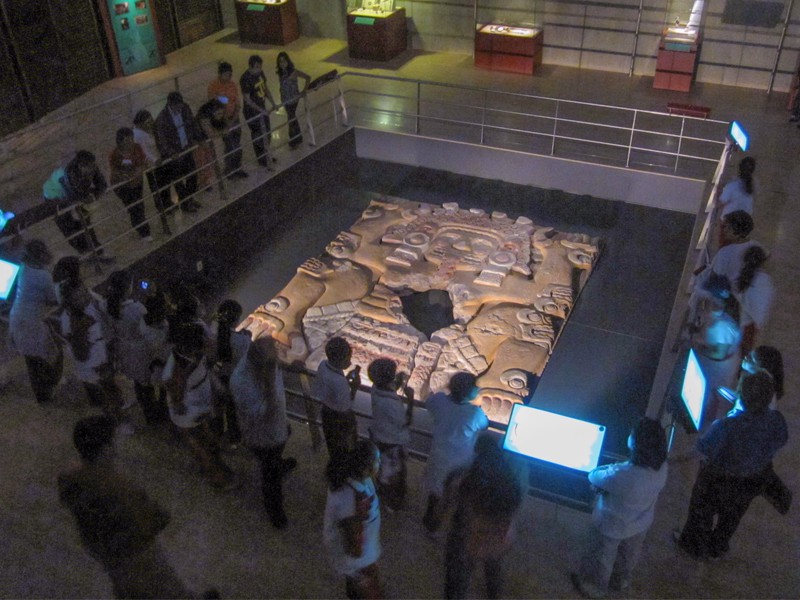 people looking at an archaeological discovery in a museum- one of the places to visit in Mexico City