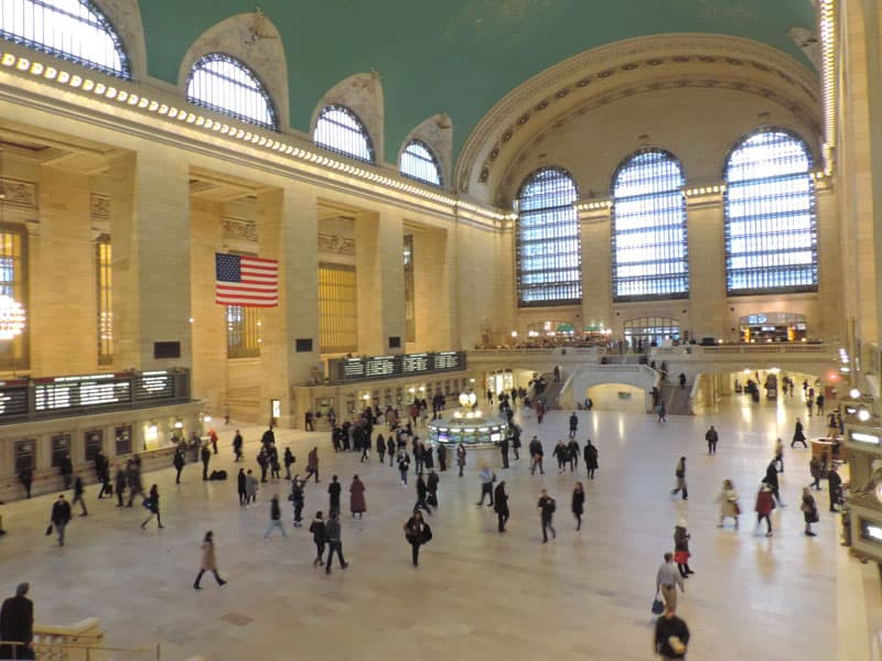 people walking through a huge train station