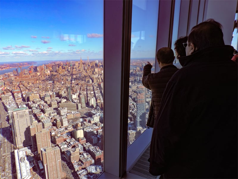 people on an observation deck looking across New York City