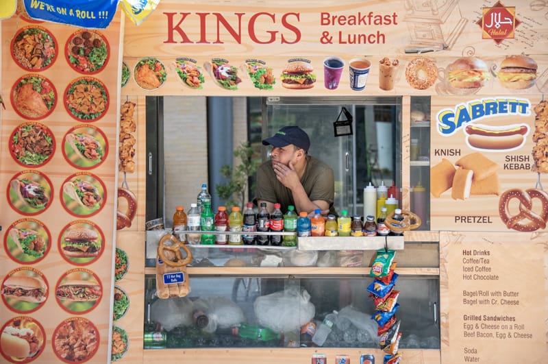 a man looking out the window of a colorful food truck