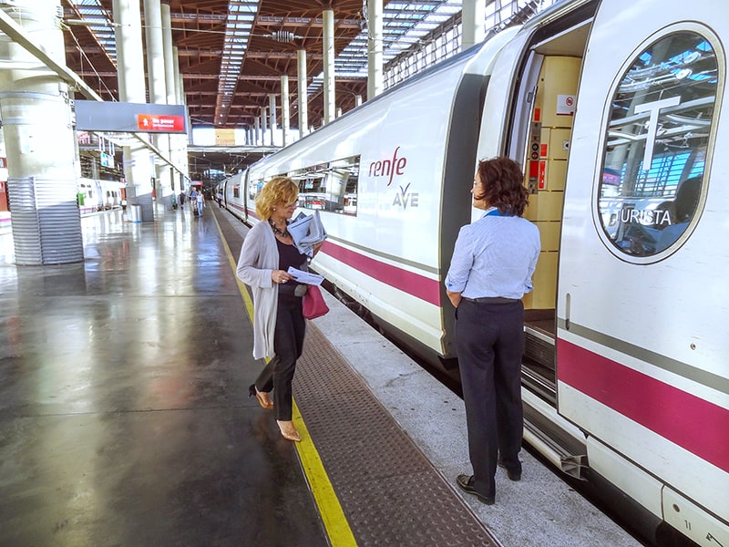 a womqn boarding a train walking past a conductor seen on a Toledo from Madrid day trip