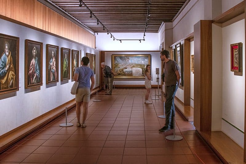 people in an art museum looking at paintings