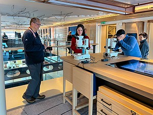 three people looking at microscopes