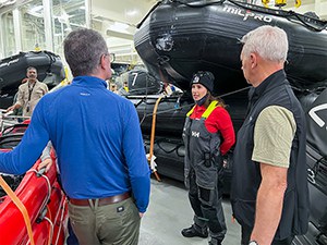 a young woman giving a tour to visitors in a hangar