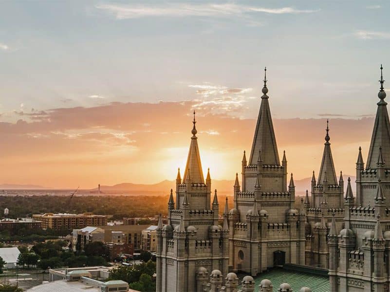 looking cross church steeples over a city at sunset, one of the things to do in salt lake city