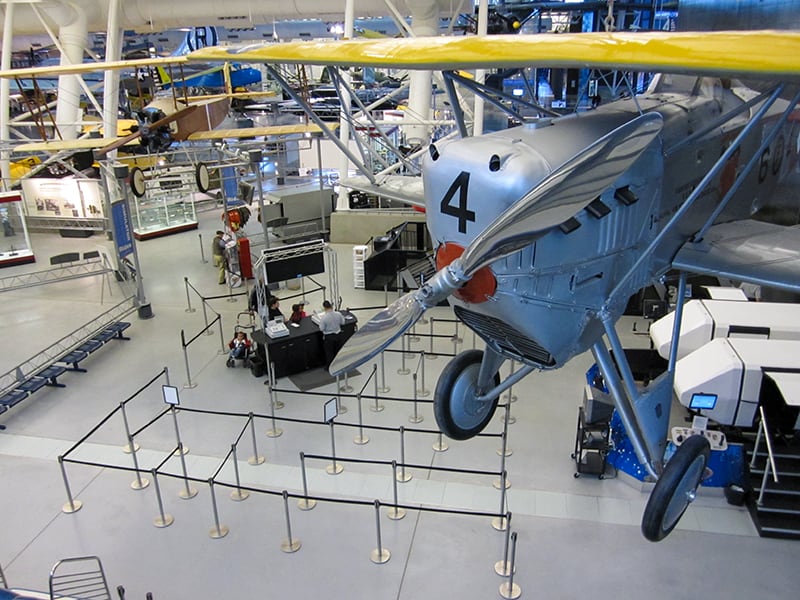 a plane with yellow wings hanging from the ceiling