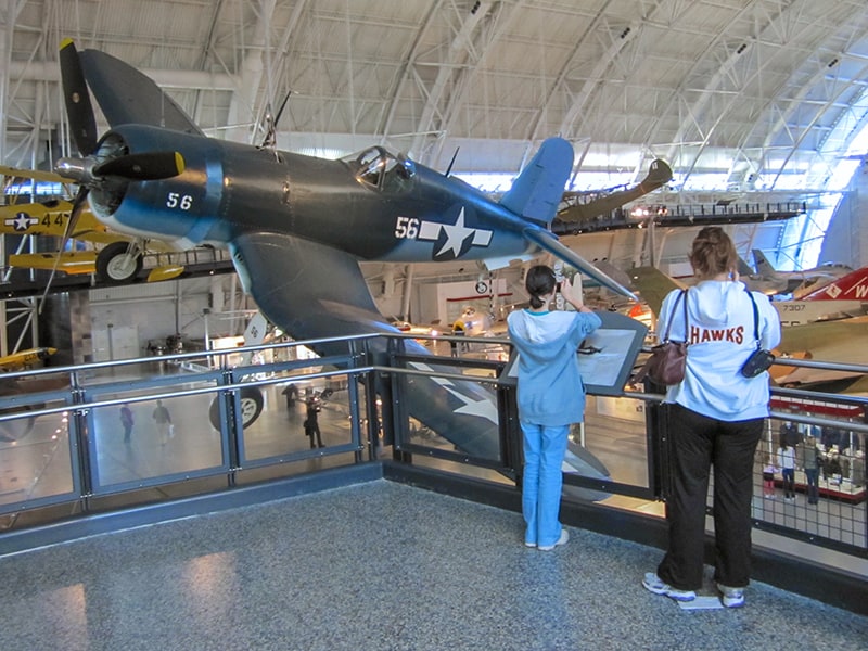 two young woman looking at a World War 2 fighter