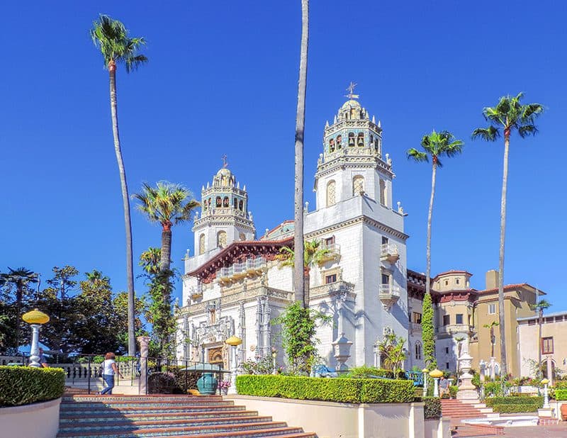 palm trees around two large while towers of a castle