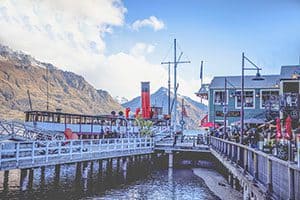 people on a dock by an old riverboat