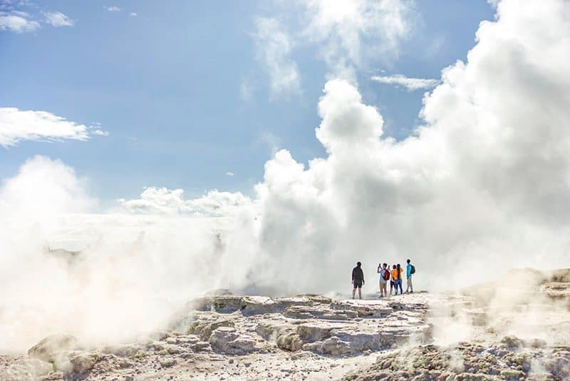 people visiting a huge thermal spring on one of teh tours in New Zealand