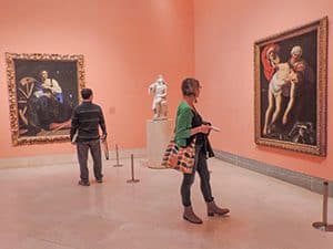 people looking at paintings in an art museum