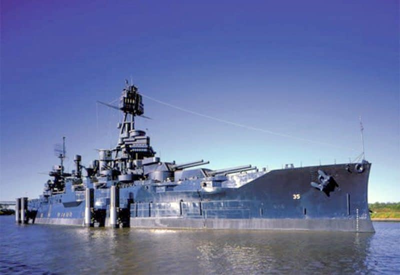 an old battleship moored at a dock