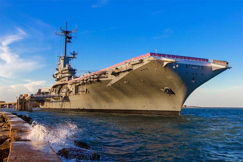 an aircraft carrier moored at a dock