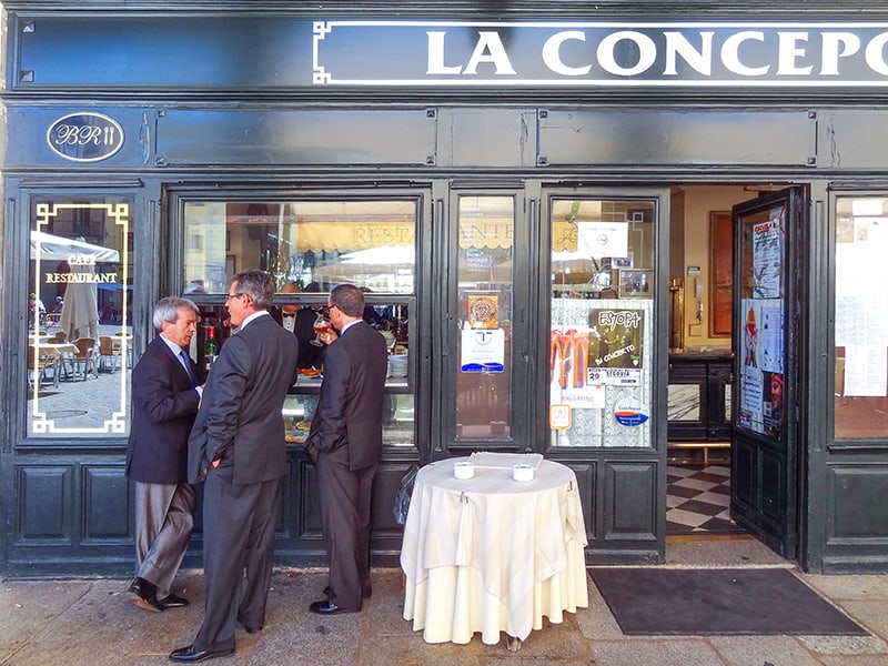 men in suits having a conversation outside a restaurant