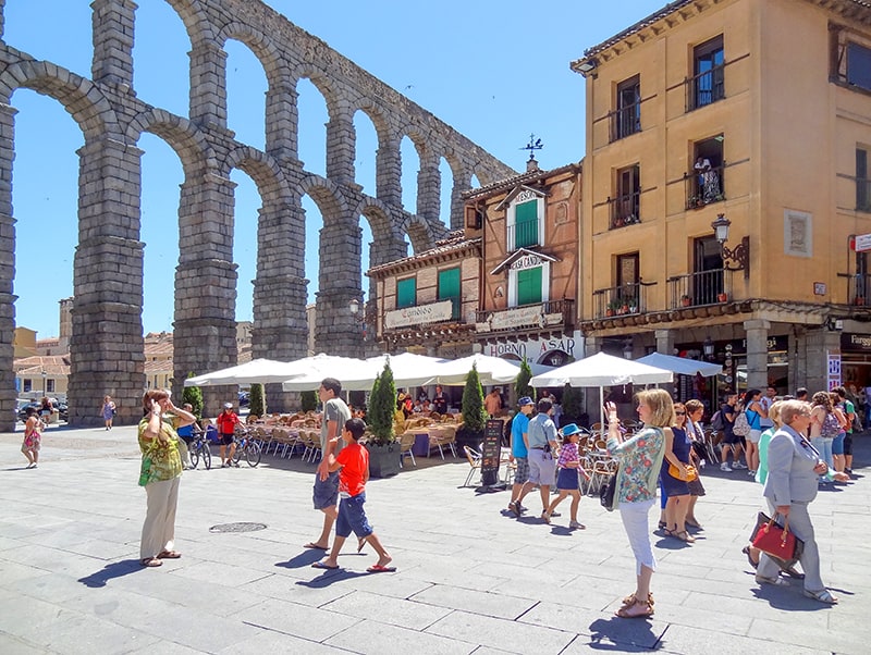 people by an ancient aqueduct in Segovia