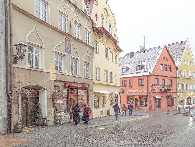 two women looking in a shop window on a snowy afternoon