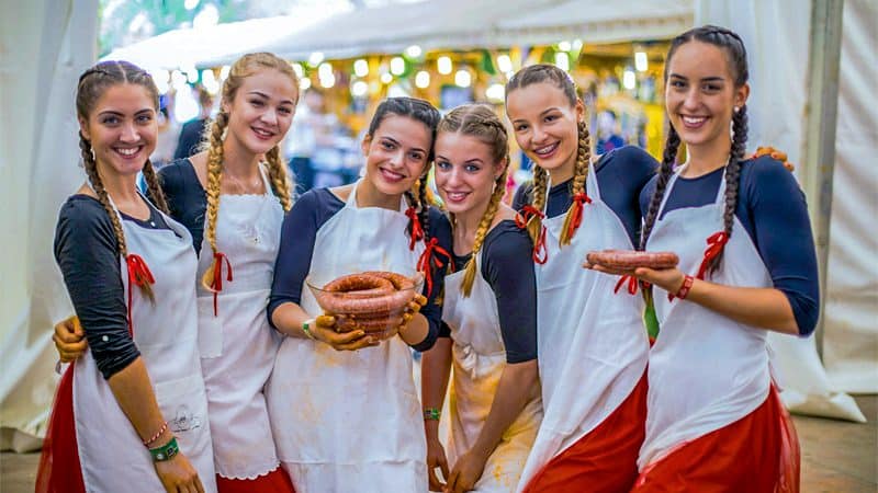 six young women holding sausages