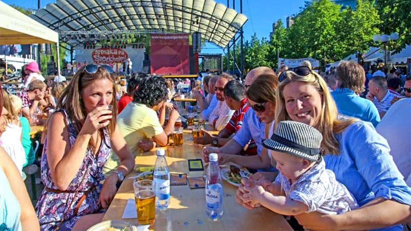 a large crowd of people sitting at outdoor tables