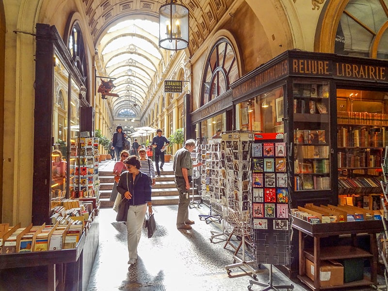 People walking through an old galerie while on walks in Paris 