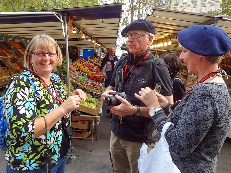 tourists standing in an outdoor market while on walks in Paris 