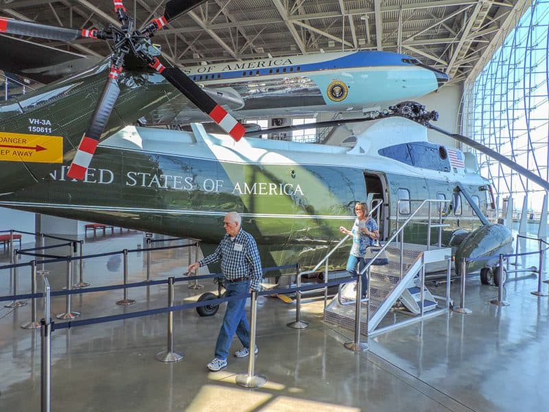 people walking past a helicopter and jet plane in the presidential museum of Ronald Regan