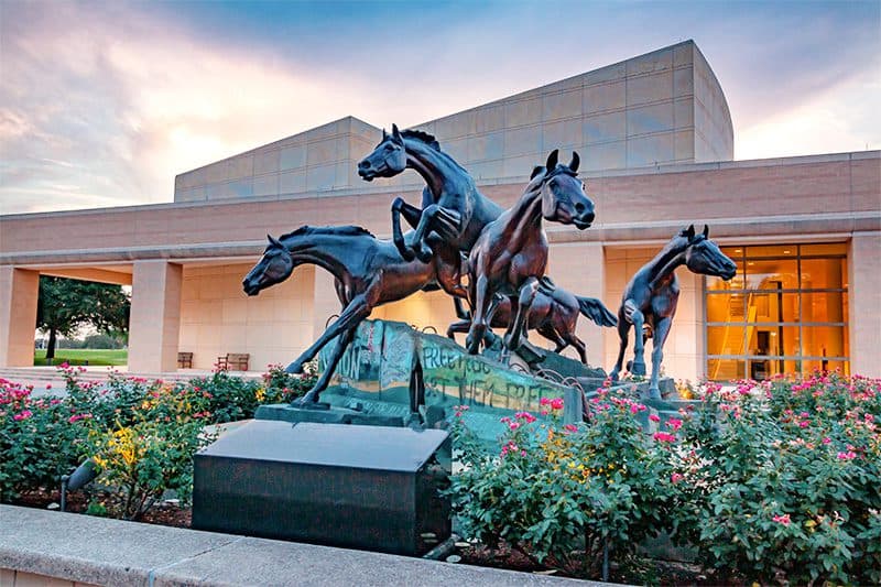 a sculpture of running stallions in the presidential museum of George Bush