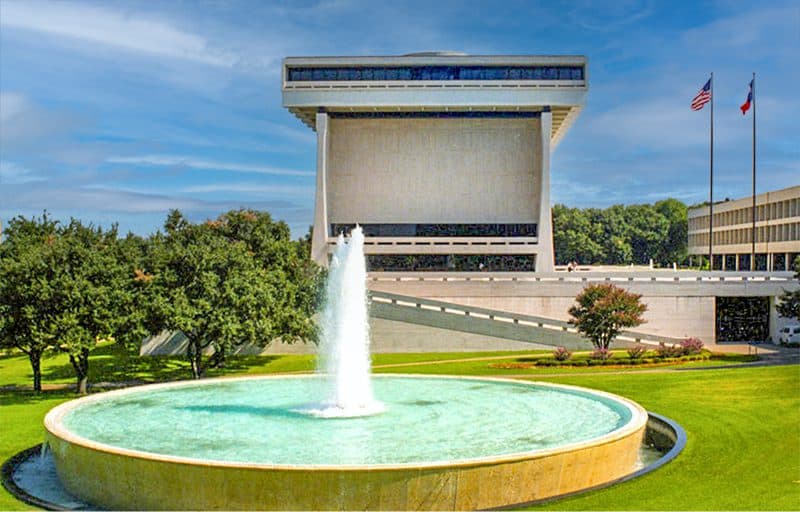 a pool and fountain in front of the presidential museum of LBJ