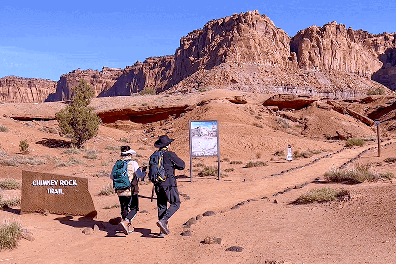 a couple walking along a hiking trail in a countryside of red-rock mountains