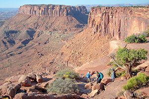 people hiking down the side of a canyon