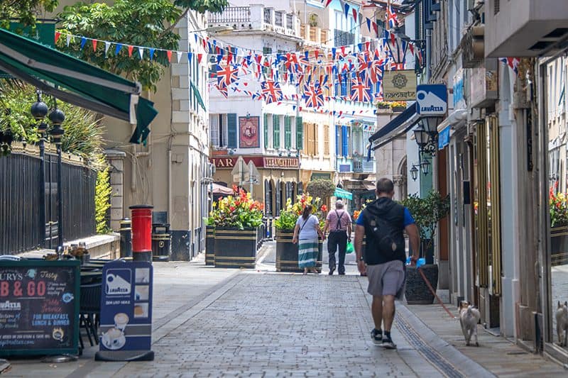 people walking down a street beneath British flags - things to do in Gibraltar video