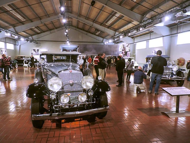 people in an old car museum