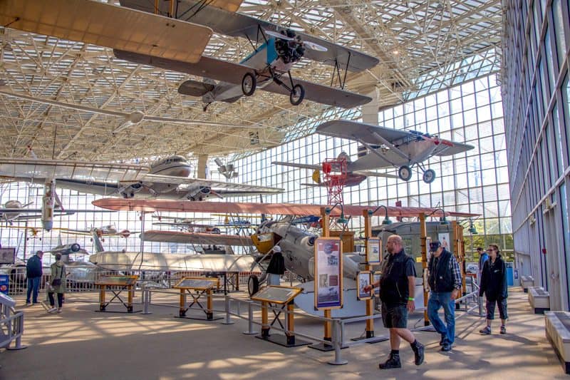 people looking at planes in a museum