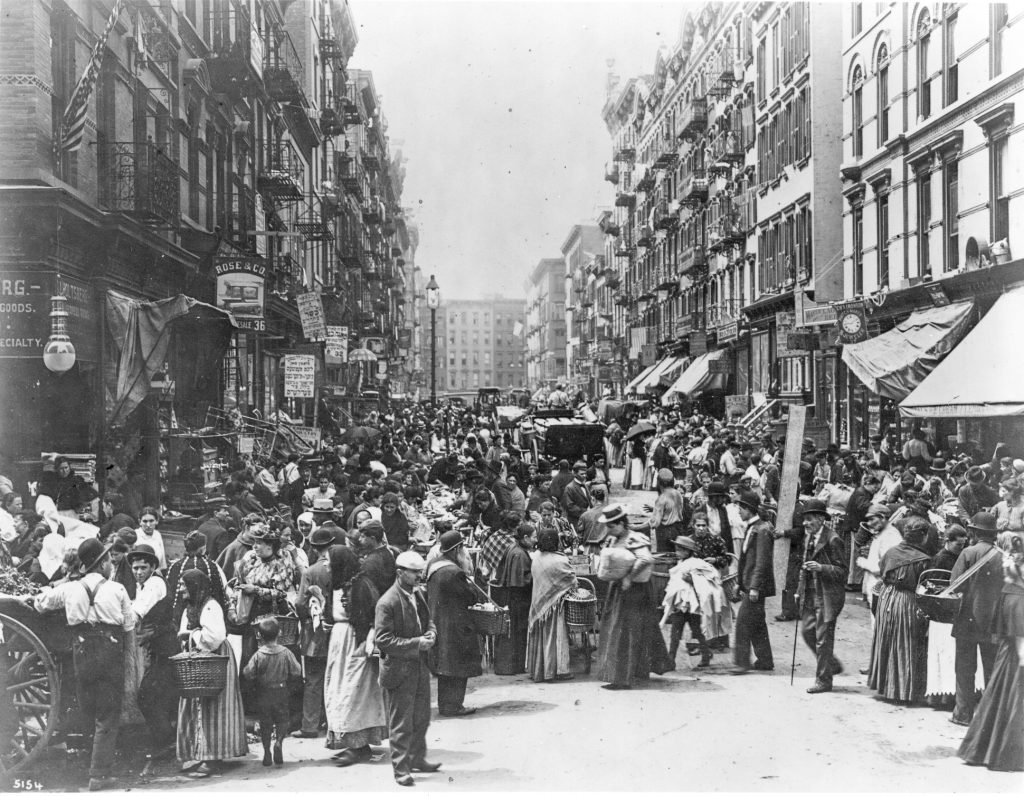 an archive photo of a crowd of immigrants on a city street
