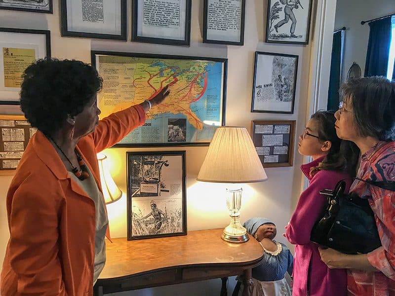a woman pointing at a map for a mother and daughter