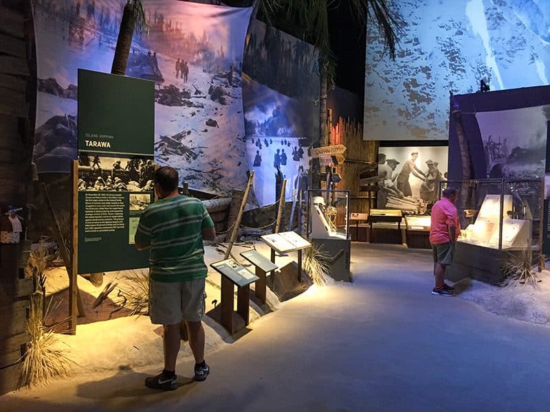 people looking at a war exhibit  in a small museum