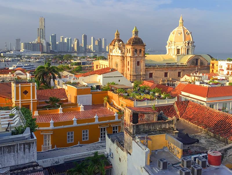 old buildings at sunset with a modern city in the distance in Cartagena Colombia
